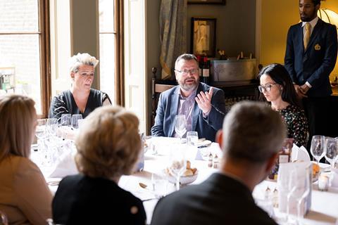 Photograph focused on ABI chief fraud and financial crime officer Mark Allen, mid-conversation at the roundtable. He wears rectangular-framed glasses and a mauve shirt with a navy blazer over the top.